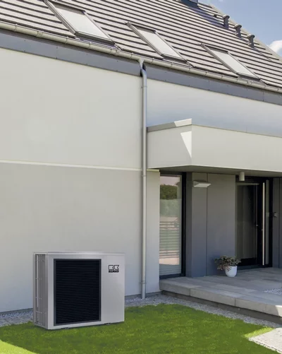 Pompe à chaleur Remko devant une maison individuelle moderne avec toit plat et lucarnes