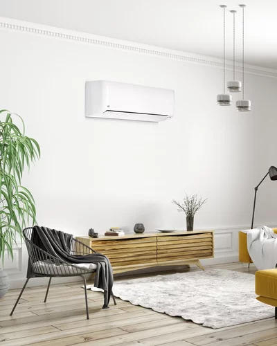 Weißes Wandgerät einer Klimaanlage in einem modernen Wohnzimmer mit gelbem Sofa und Holzregal.
