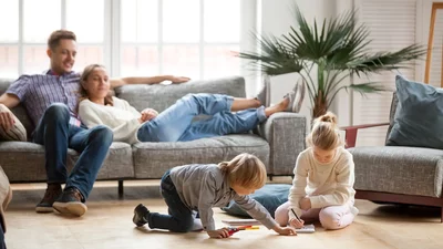 Familie entspannt im Wohnzimmer, Kinder malen auf dem Boden