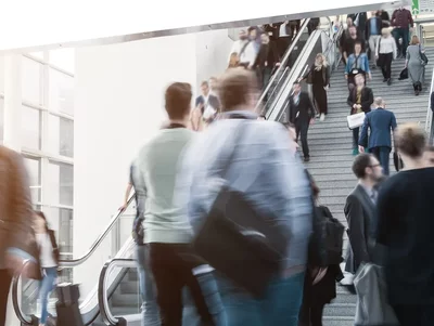 Messebesucher eilen durch die Messehallen