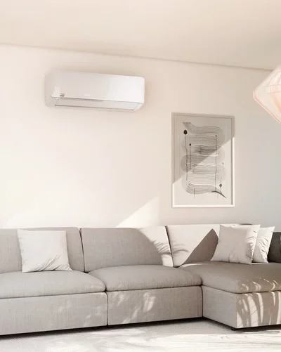 Lichte woonkamer met een grijs hoekbank en een witte Remko wandluchtbehandelingsunit.