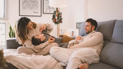 Glückliche Familie entspannt sich auf einem Sofa im Wohnzimmer