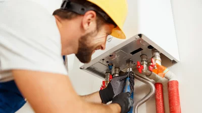 Handwerker montiert eine Heizungsanlage an der Wand