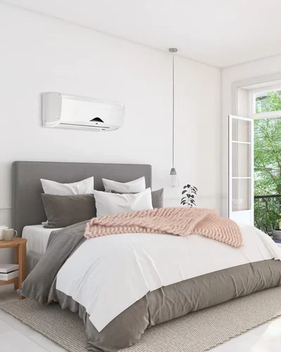 Schlafzimmer mit weißer Wandklimaanlage über dem Bett und offenen Fenstern