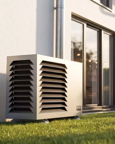 Remko warmtepomp in de tuin voor een huis, terwijl mensen op de achtergrond grillen.