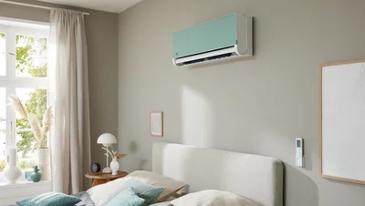 Remko Klimagerät an der Wand in einem hellen Schlafzimmer mit Bett und Fenster