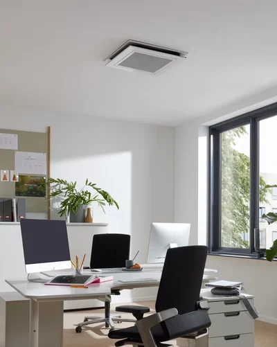 Deckengerät für Klimaanlage in einem modernen Büro mit Schreibtischen und Fenstern