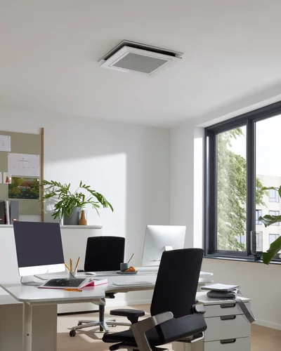 Deckengerät für Klimaanlage in einem modernen Büro mit Schreibtischen und Fenstern